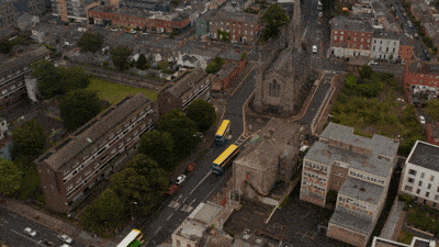 High_Angle_View_Of_Group_Of_Colourful_Buses_Driving_Through_Town._Traffic_Around_original_2241834